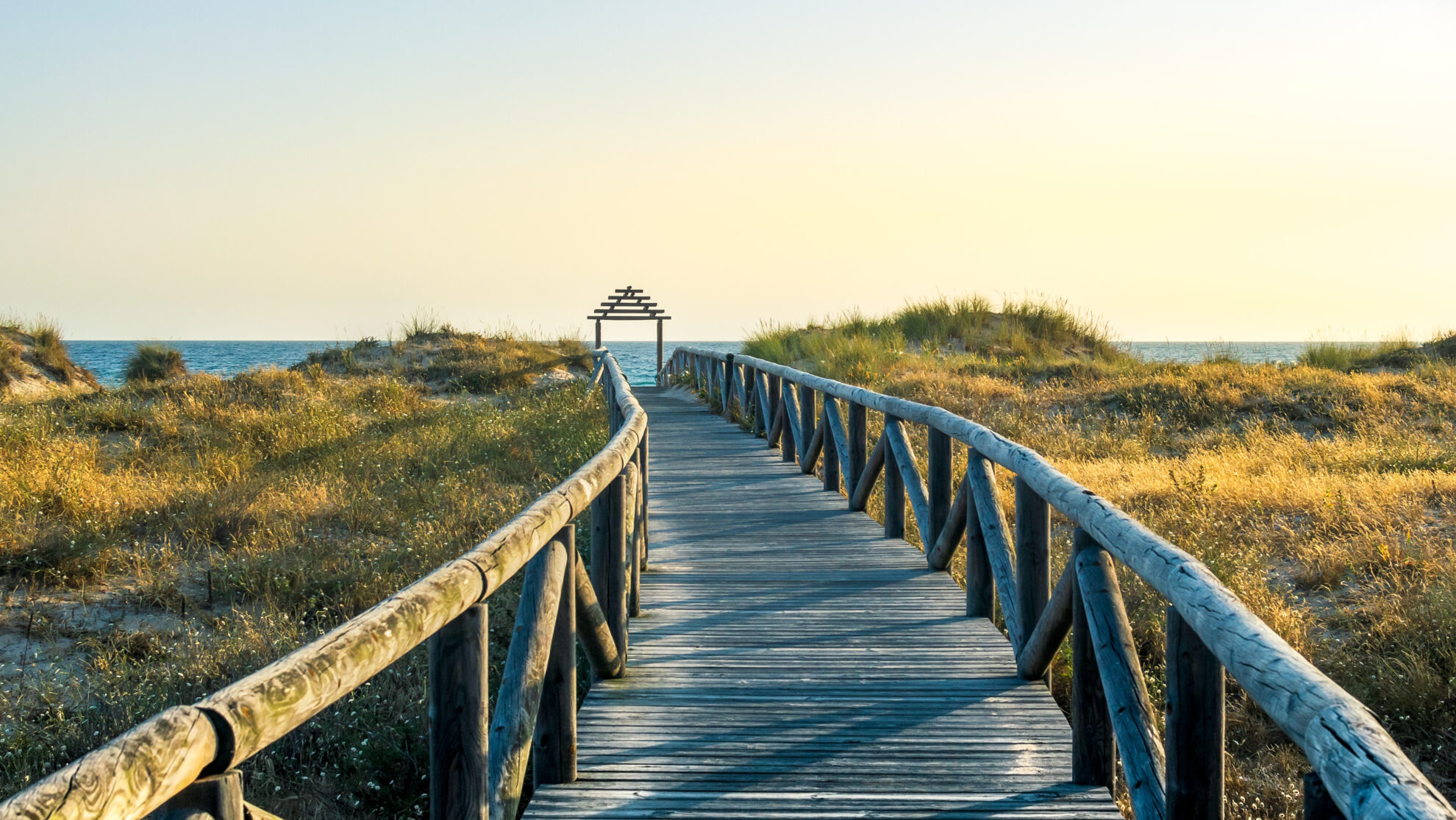 Wooden Deck On A Field Surrounded By The Sea Under The Sunlight In 